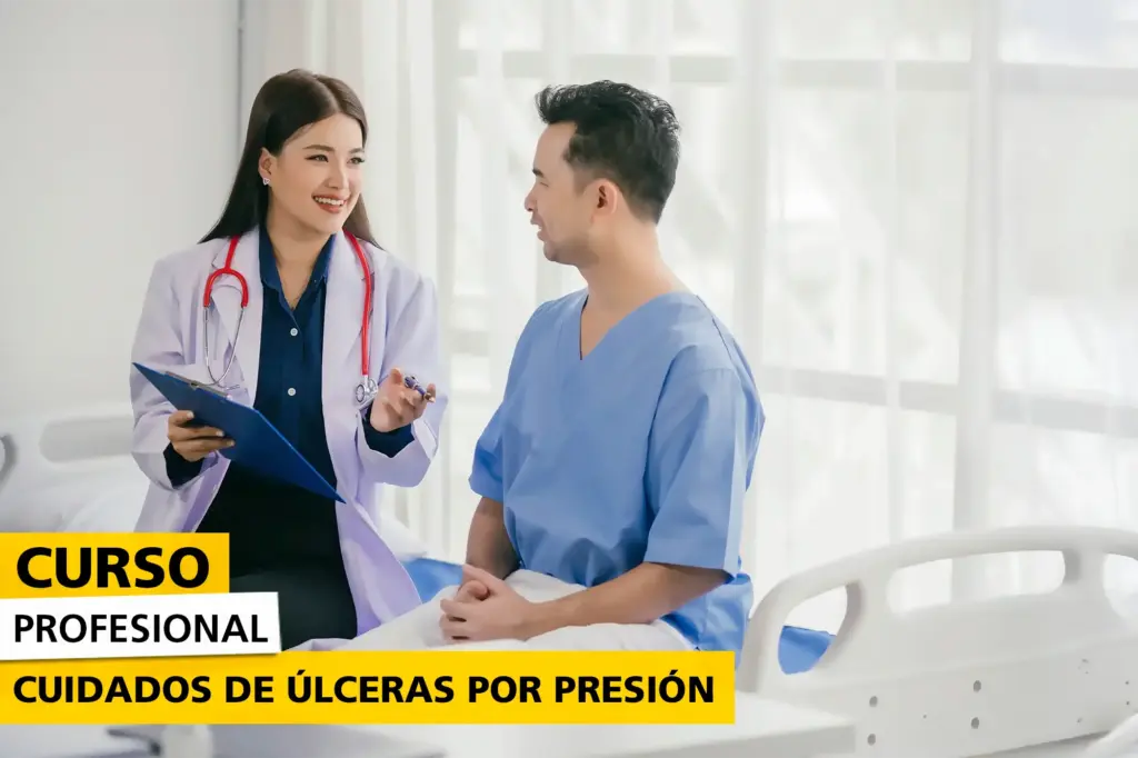 Doctora con bata blanca y estetoscopio conversando con un paciente en bata azul en una cama de hospital. Imagen promocional del curso sobre cuidados de úlceras por presión.
