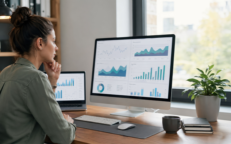 Profesional analizando cuadros de mando, gráficos e indicadores en un ordenador para la creación de informes y visualización de datos empresariales.
