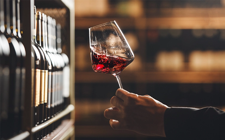 Persona catando en una bodega una copa de vino