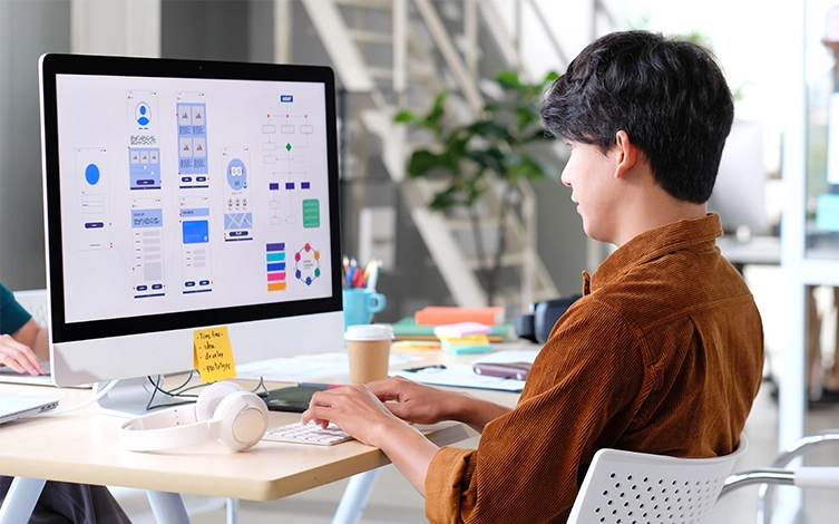 alumno diseñando una interfaz web en un ordenador, orientado al aprendizaje de desarrollo web, diseño de páginas, HTML, CSS, mantenimiento web y publicación de sitios web profesionales.