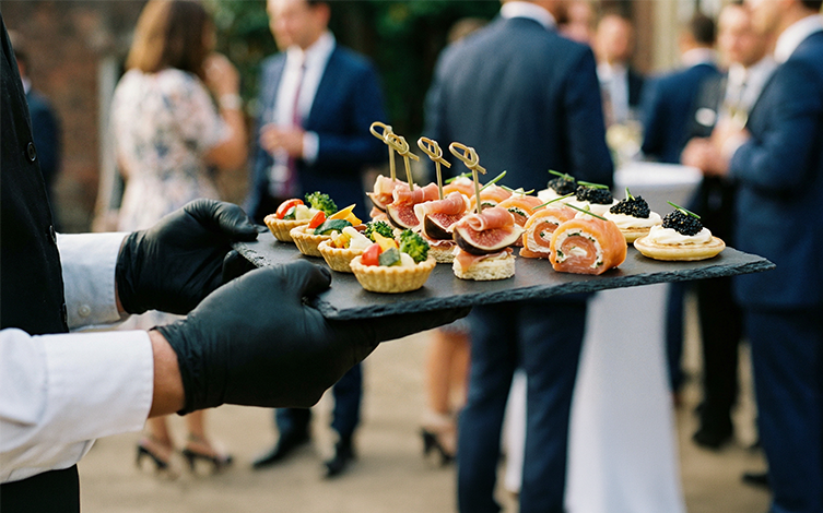 Camarero ofreciendo una bandeja de canapés a los asistentes